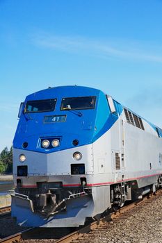 Blue and sliver lead train engine against a blue sky