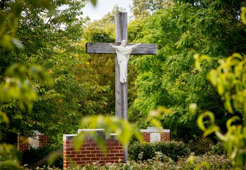 Statue of Christ being crucified on cross in stations of the cross in garden