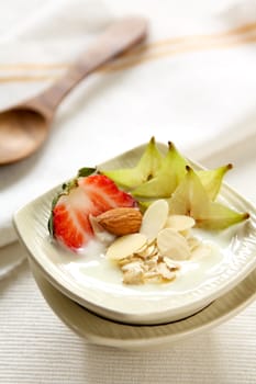 Yogurt with strawberry,starfruit and almond in small bowl