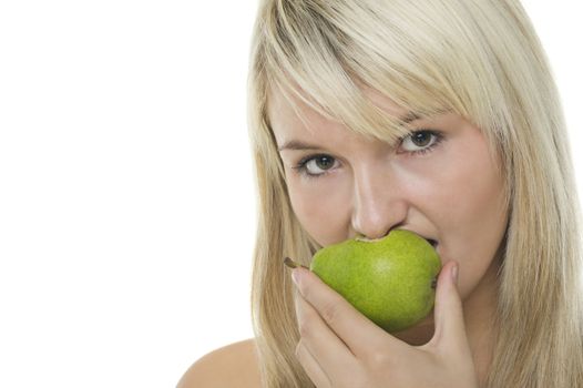 Attractive young blonde woman eating a half eaten healthy green pear, studio headshot isolated on white