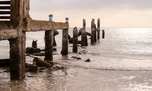 Old jetty in sea in overcast sky day evenning time