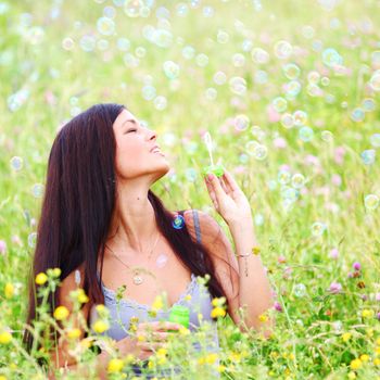  happy woman smile in green grass soap bubbles around