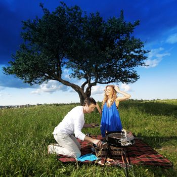 man and woman on picnic in green grass