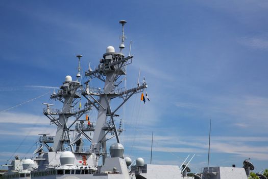 Upper Profile of part of the deck of a Navy Cutter with radar and guns against blue sky