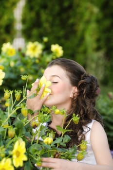 Young little girl holding and smelling a beautiful flower