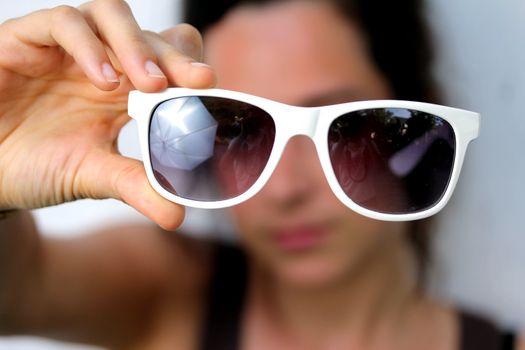 young woman holding sunglasses