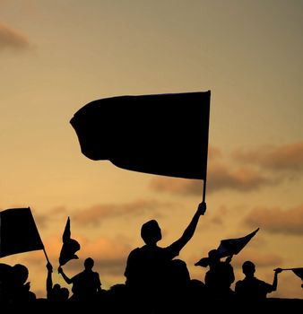 silhouette of street protestors with flags and banners