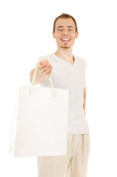 Smiling handsome man is presenting white gift paper bag, isolated on white. Focus on the hand.