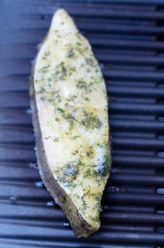 Raw Greenland Halibut fillet steak being grilled on BBQ