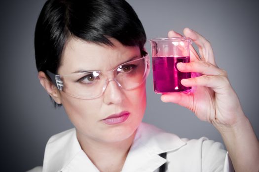 young brunette female doctor checking laboratory samples with protective glasses, career women, research