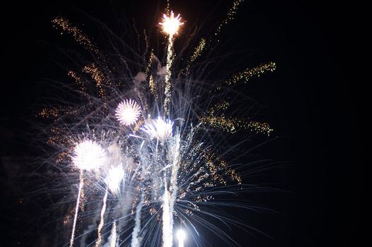 A delicate burst of fireworks in the night sky with room for your copy text (happy new year)