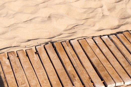Weathered wooden boardwalk on sand on Crete Island in Greece