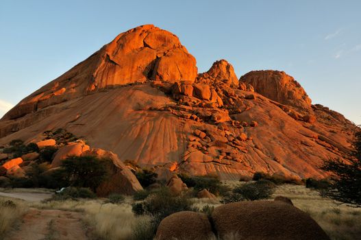 Spitzkoppe in Namibia at sunset. The sandstone becomes a deep orange during sunset