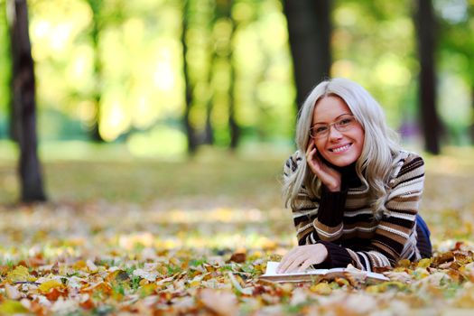 woman read the book in autumn park