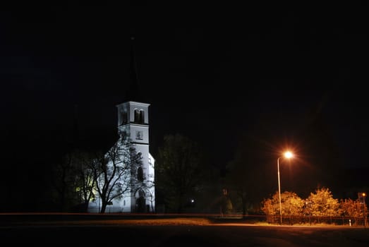 Night photo of a baroque chapel lit by a lamp at night