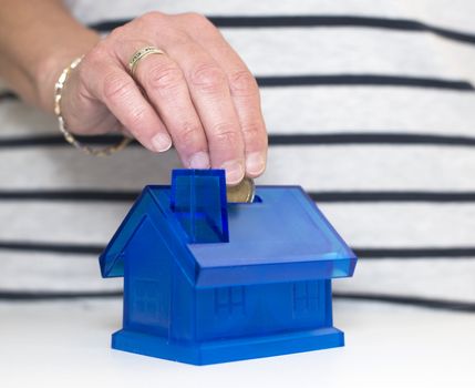 female hand putting money in the house