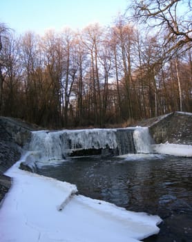  River is covered by icicles and a weir is completly frozen