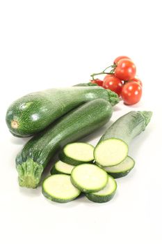 fresh zucchini with red tomatoes on a light background