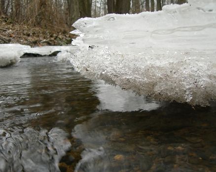   River is covered by icicles and  is lit by a sun         