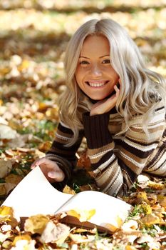 woman read the book in autumn park