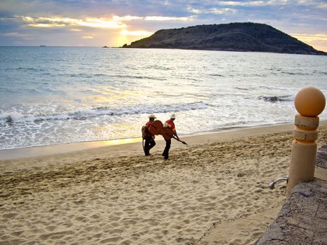 MAZATLAN, SINALOA/MEXICO � FEBRUARY 7: Two Mariachi musicians stroll on beach at sunset carrying their instruments heading for the next tourist performance shown on February 7, 2010 in Mazatlan