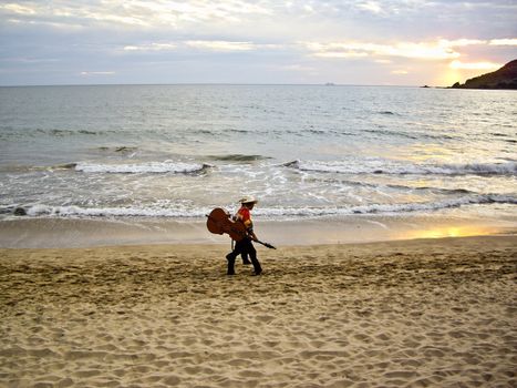 MAZATLAN, SINALOA/MEXICO � FEBRUARY 7: Two Mariachi musicians stroll on beach at sunset carrying their instruments heading for the next tourist performance shown on February 7, 2010 in Mazatlan