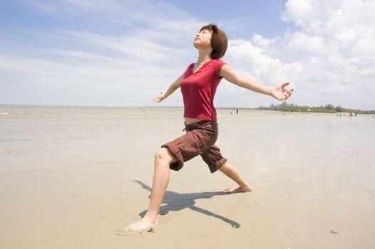 asian girl performing yoga on a beach