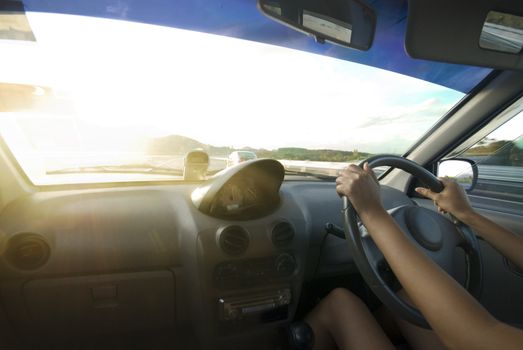 a driver driving towards sunset