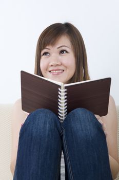 asian girl reading on a sofa 