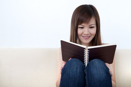 Women Reading a Book on Sofa