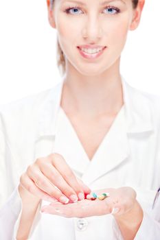 Pretty female nurse holding  pills, focus on pills