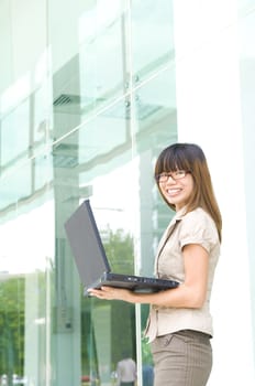 asian business women smiling with a laptop 