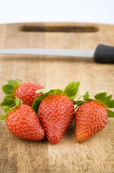 strawberry on a chopping board and kitchen knife, looks good for ingredients