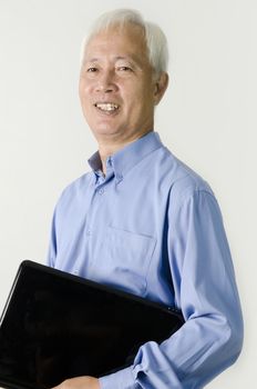 senior asian business man holding a laptop and msiling 