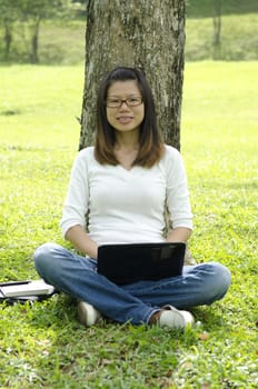 young college asian girl using laptop outdoor 