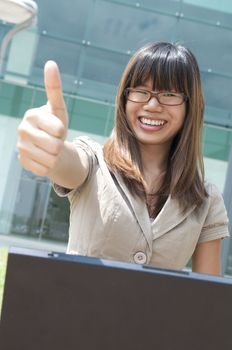 asian business women with a laptop and thumbs up