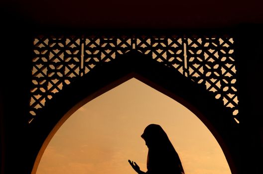 silhoutte of muslim woman praying during fasting holy month of ramadan