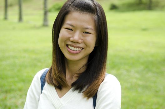 asian girl smiling on green outdoor