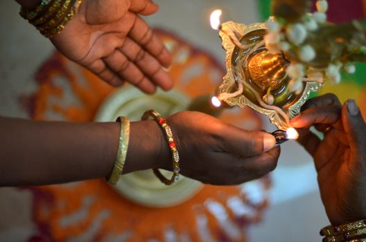 hands lighthing oil lamp during deepavali ceremony