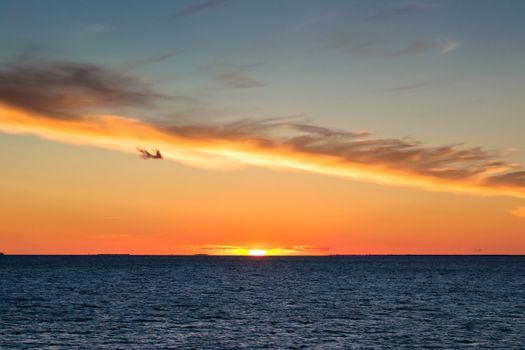 Beautiful sunset with cloud like a line and rippled sea