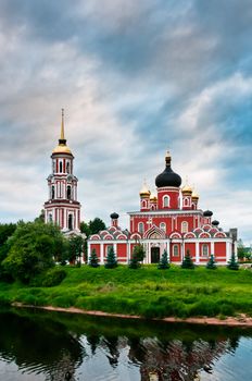 Red church on coast of the lake in Russian village