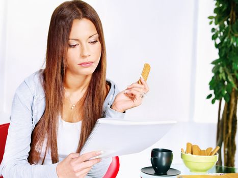 Woman at home reading from notebook