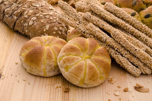 Variety of Organic Breads on plank background ,golden lights were used 