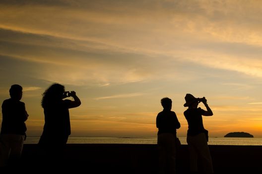 sihoutte of tourists snapping photos