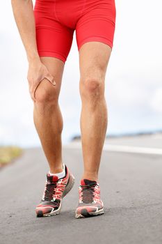 Knee pain - running sport injury. Male runner having knee problems during exercise outside.