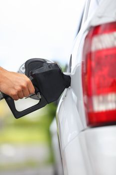 Gas station pump. Man filling gasoline fuel in car holding nozzle. Close up.