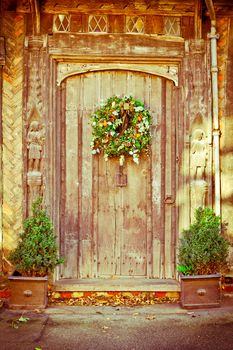 A decorative traditional christmas wreath on an old door