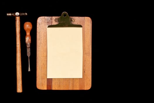 Work tools and a clipboard isolated on a black background