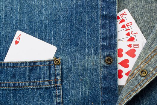 Close-up photograph of playing cards on denim material.