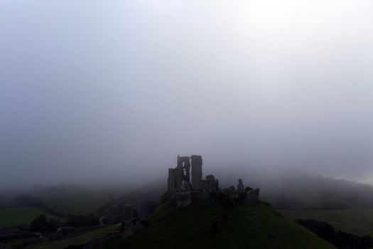 Norman dark ages castle ruin in dorset england in thick sea mist